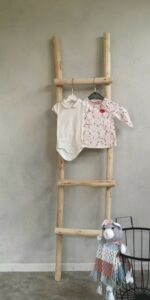 houten ladder in babykamer met babykleertjes