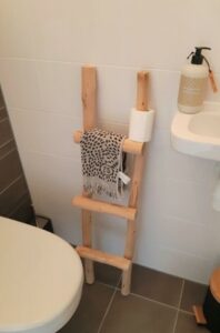 Holzleiter in der Toilette mit Toilettenpapier und Handtuch