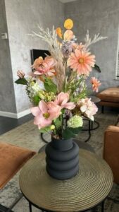 Schwarze hohe Vase mit rosa Kunstblumen