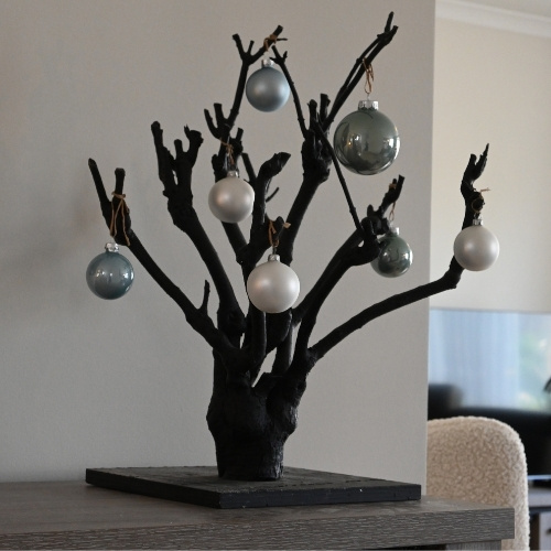 Zwart-kerstboompje-op-dressoir-woonkamer-Decoratietakken